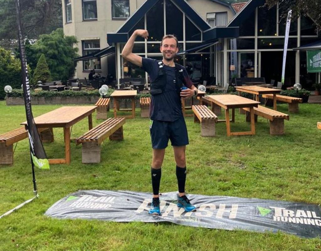 Hybride atleet met gebalde vuist na de finish van een trailrace