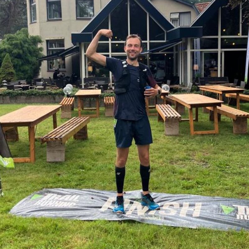 Hybride atleet met gebalde vuist na de finish van een trailrace